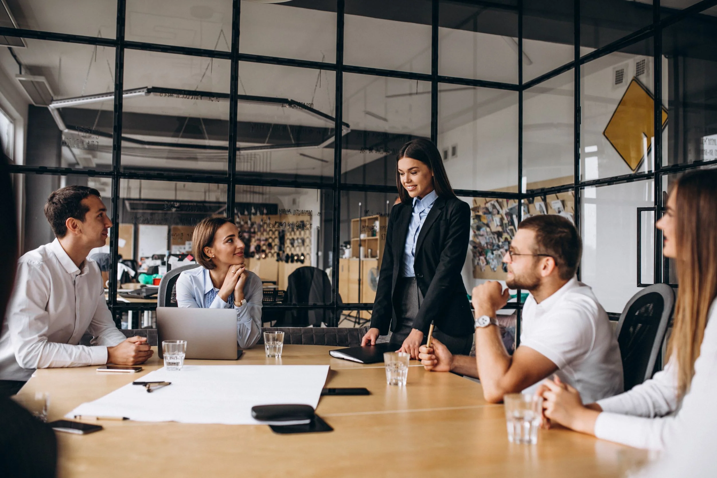 Employees collaborating in a bright workspace with natural lighting and flexible seating